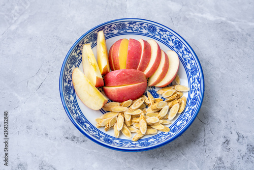 Bild auf Leinwand A plate of sliced ​​apples and astragalus root