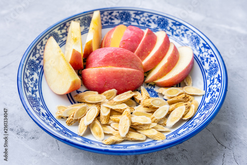 Bild auf Leinwand A plate of sliced ​​apples and astragalus root