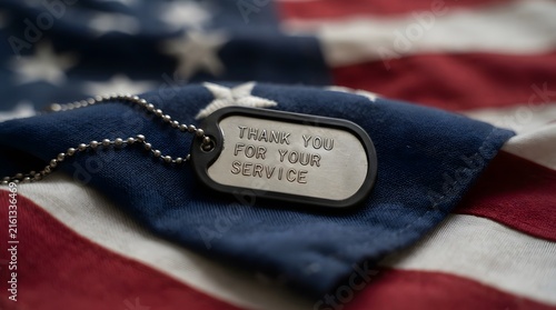 Plakat w ramie American dog tag resting on a blurred united states flag background representing military service