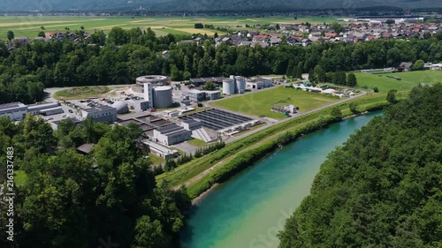 The picture shows a large wastewater treatment plant with settling tanks and filtration systems.
