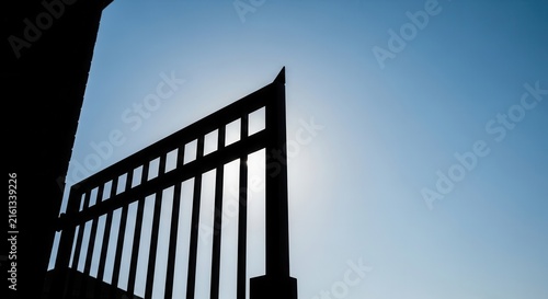 Silhouette Of An Open Gateway Against A Clear Blue Sky