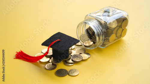 Graduation Cap on Pile of Gold Coins Spilling from Glass Jar Concept of Education Fund Savings and Tuition Fees