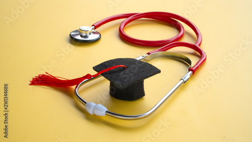 Graduation Cap Inside Red Medical Stethoscope for Medical Education Cost and Healthcare Degree Concept