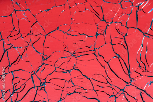 Fotografie Red shattered glass surface creating abstract cracks pattern