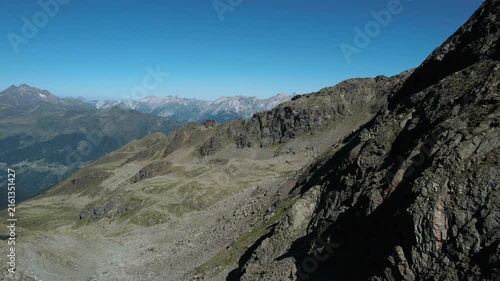 Beautiful drone footage of green mountain ranges and a clear blue summer sky.