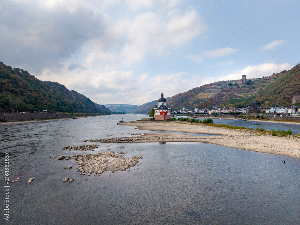 Naklejka premium A view of the Pfalzgrafenstein Castle on the Rhine River during low water at Kaub, surrounded by hills, vineyards, and the castle Gutenfels