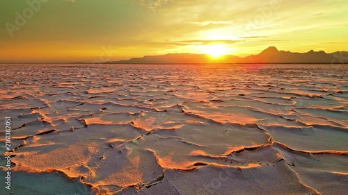 Golden sunset light illuminating distinctive hexagonal salt crust patterns across the Bonneville Salt Flats in Utah