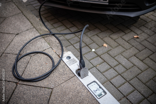 Ein E-Auto wird an einem Ladebordstein auf der KÖ mit einem Kabel aufgeladen, Düsseldorf, Deutschland