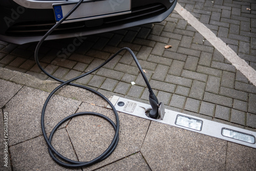 Ein E-Auto wird an einem Ladebordstein auf der KÖ mit einem Kabel aufgeladen, Düsseldorf, Deutschland