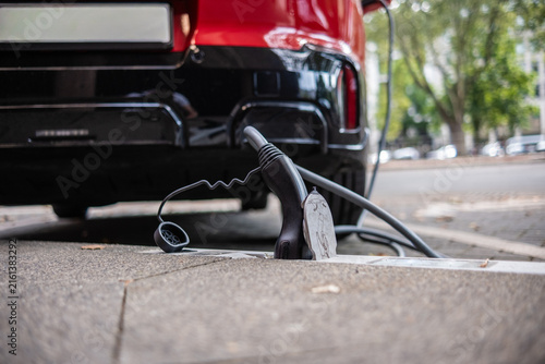 Ein E-Auto wird an einem Ladebordstein auf der KÖ mit einem Kabel aufgeladen, Düsseldorf, Deutschland