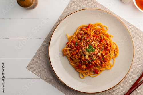 Spaghetti with minced pork in tomato sauce, pasta with a meat based bolognese tomatoes in white plate.Top view.