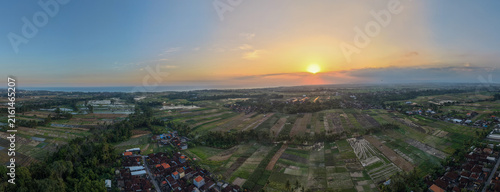 Foto Aerial Panoramic View of Rice Fields and Village Landscape at Golden Sunset