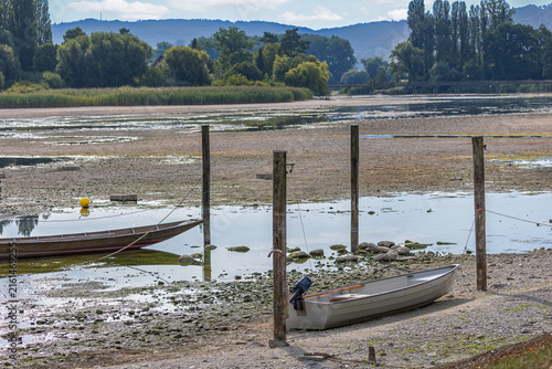 The Rhine river of the Lower Rhine from Lake Constance reached the record low water lever, due to permenant draught. Water body shrink and raval banks are largely exposed and boats lay dry on land.