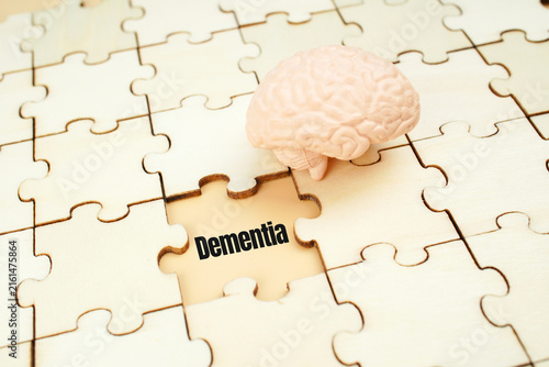 Dementia concept with human brain model and puzzle pieces, representing memory loss, cognitive decline, neurological disorder, aging and mental health awareness.
