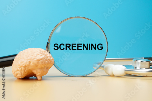 Brain screening concept with human brain model, magnifying glass and stethoscope, representing neurological examination, early detection, diagnosis and brain health assessment.