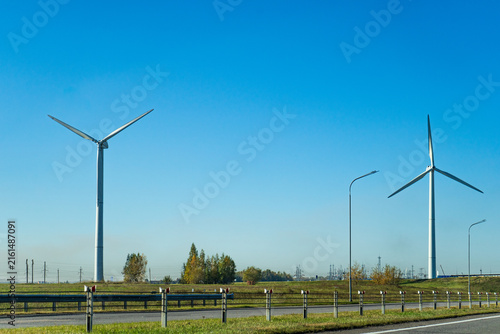 Modern wind turbines of a wind farm producing clean renewable energy under a clear blue sky.