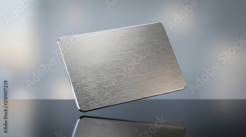 Blank metal credit card floating above a dark reflective surface