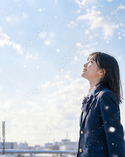 Tapety artystyczne 雪が舞う冬空を見上げる女子高校生 受験・進路・未来をイメージした教育素材