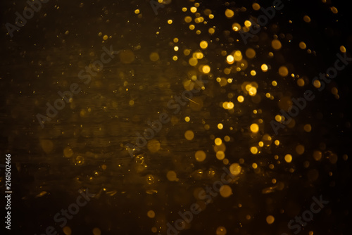 Blurred photo with golden dots visible glittering, shining brightly look and feel luxurious Suitable for use as a wallpaper
