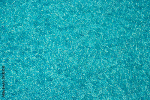 Vibrant blue water surface with shimmering reflections and ripples under sunlight