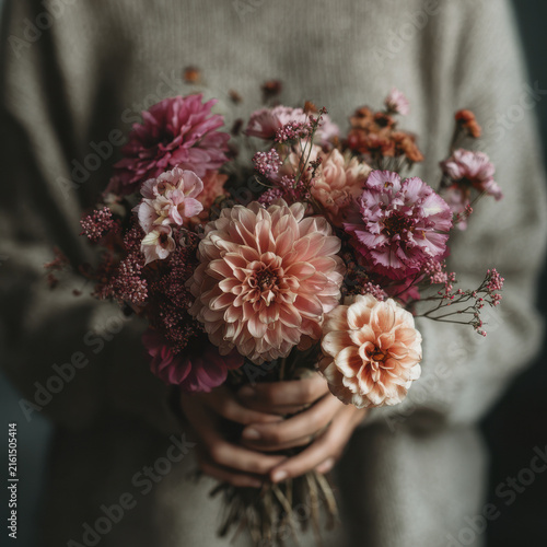Woman holding a beautiful bouquet of pink and orange dahlias