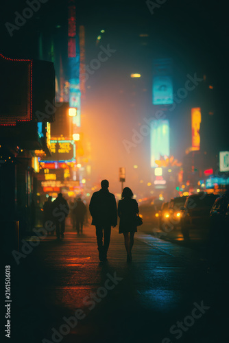 Tourists walking at night in Times Square, New York City