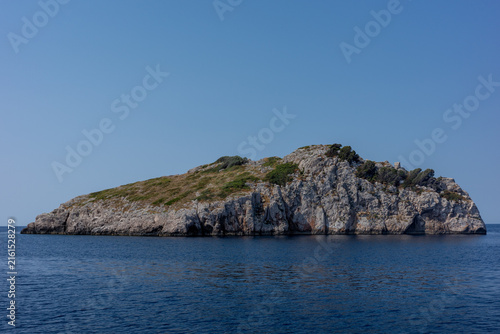 Фотография Rocky uninhabited island in calm blue sea