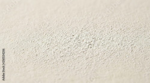 Macro shot of white chalk coated paper texture with rough grainy surface detail