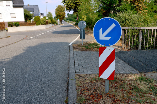Konstfotografi Keep left sign guiding traffic safely around a roadside obstacle in Germany