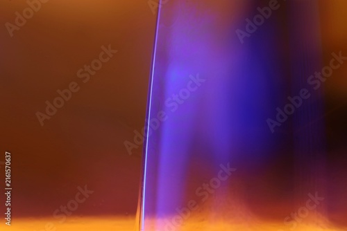 Canvas Print Glowing violet fluid column with crisp specular rim and warm amber bokeh