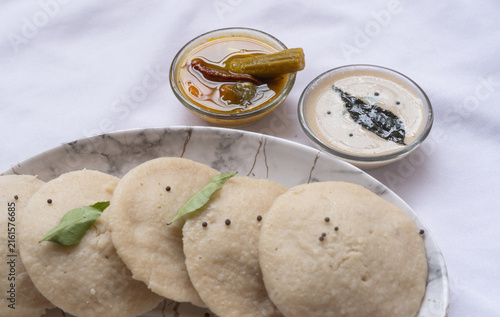 Canvastavla Idli with Sambar and coconut chutney, South Indian favourite food rava idli or semolina idly or rava idly, served with sambar and white coconut chutney on white plate
