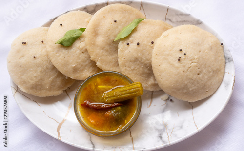 Cuadro en lienzo Side view of hot and steaming idly in a white plate and sambar in a isolated white background