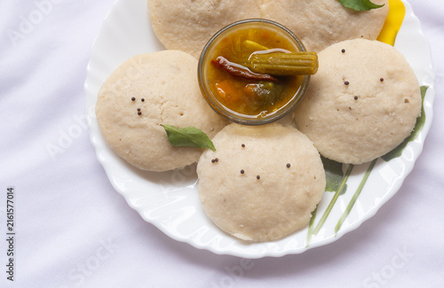 Photography Hot and steaming idly in a white plate and sambar in a isolated white background