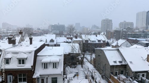 Snow-covered Urban Landscape with Residential Homes and City Skyline in Winter Weather, Capturing a Quiet, Blustery Atmosphere