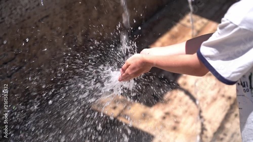 Child’s hands under running water, playful water activity and everyday hygiene concept