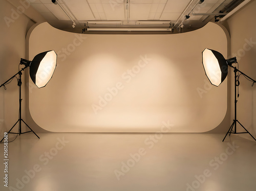 Empty professional photo studio with white cyclorama wall and studio lighting equipment