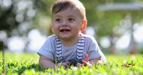 Photography Adorable baby laid on grass in outdoors nature smiling and laughing