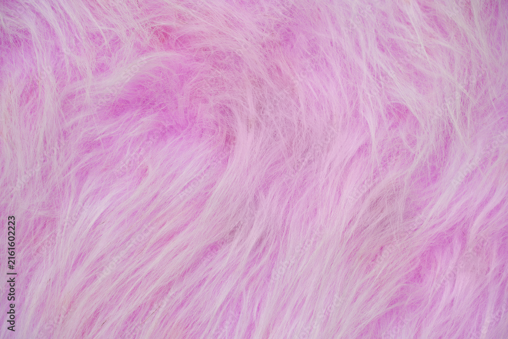 Fototapeta premium Pink Faux Fur Surface Displayed Closeup Showing Soft Long Fibers And Fluffy Texture For Fabric Or Textile Backdrop.