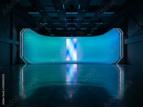Virtual production studio stage with curved LED screen and blue ambient lighting.