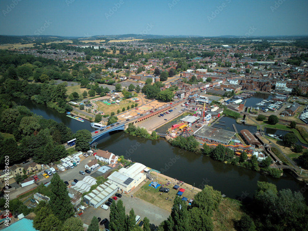 Fototapeta premium Aerial drone view of Stourport-on-Severn town centre, Worcestershire, England. Bird's eye perspective of the historic market town, streets, red brick buildings, and surrounding landscape.