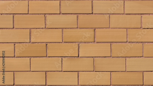Close-up color background photo of a plain brown ceramic tile wall with red tinted mortar