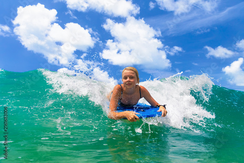 Bild auf Leinwand Happy young surfer girl with bodyboard have fun on beach, riding on small ocean waves