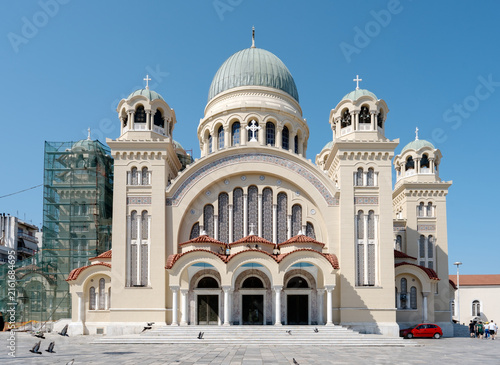 Agios Andreas Cathedral featuring a prominent dome and multiple towers against a blue sky in Patras, Greece.