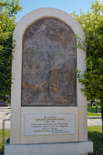 Artistic stone relief carving displaying historical craftsmanship, surrounded by trees in natural setting.