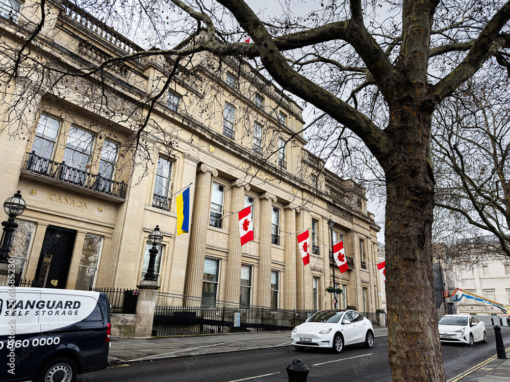 Fototapeta premium Canadian embassy building with flags and pedestrians on a London, UK street in winter