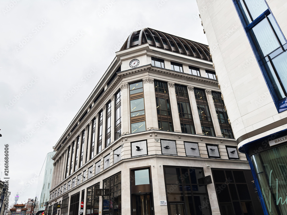 Naklejka premium Historic department store building with clock tower and modern shops on a London, UK Panton street