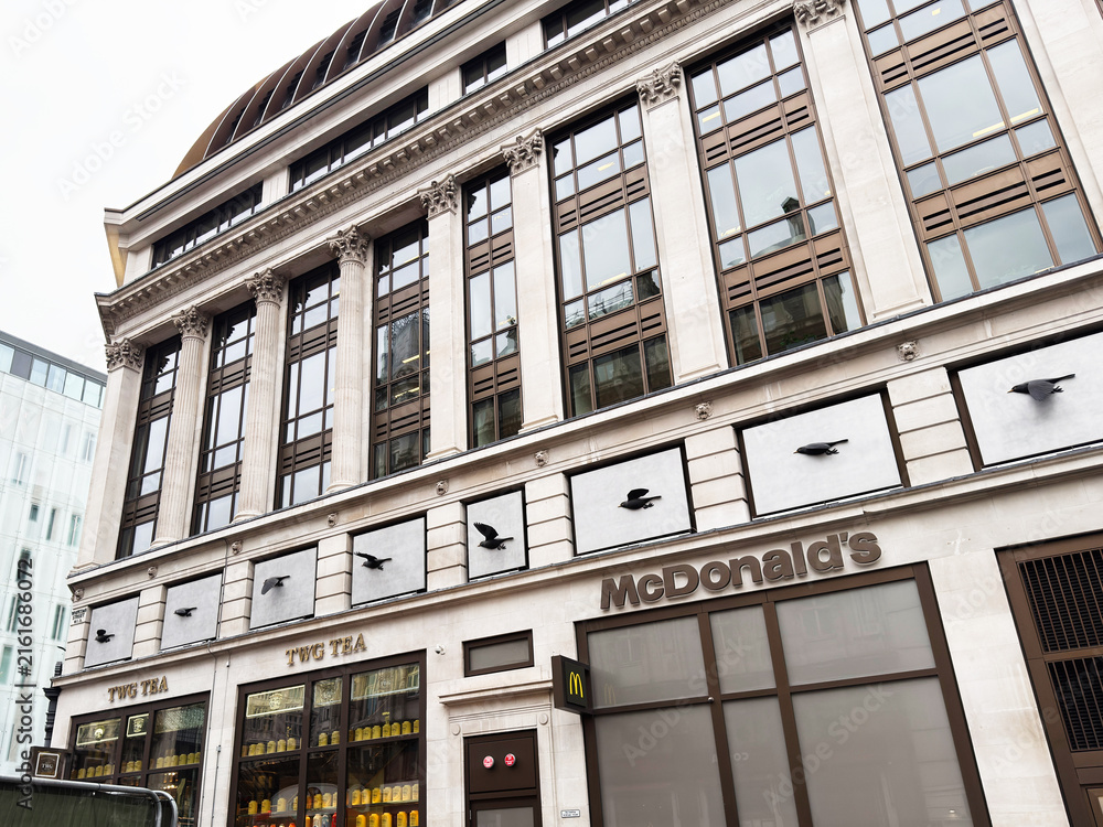 Naklejka premium McDonalds and TWG Tea storefront on a historic commercial building facade in London, UK