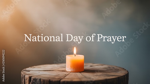 National day of prayer text overlay with a glowing candle on a rustic wooden table background