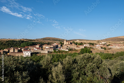 Traditional Stone Village with Church Tower on Sunny Hillside