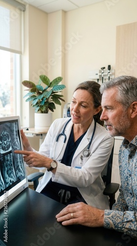 Doctor And Patient Discussing Medical Scan Results In Clinic